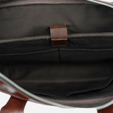 Burgunddy  leather bag with a strap on a white background